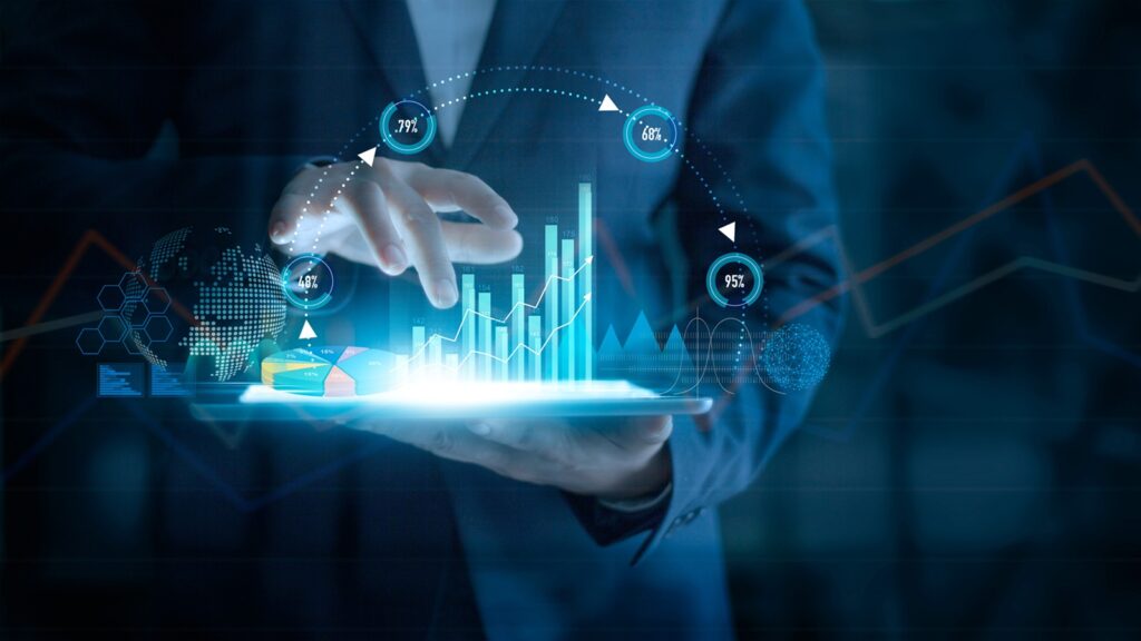 Geschäftsmann nutzt ein Tablet, auf dem Diagramme und Zahlen hervorgehen.
