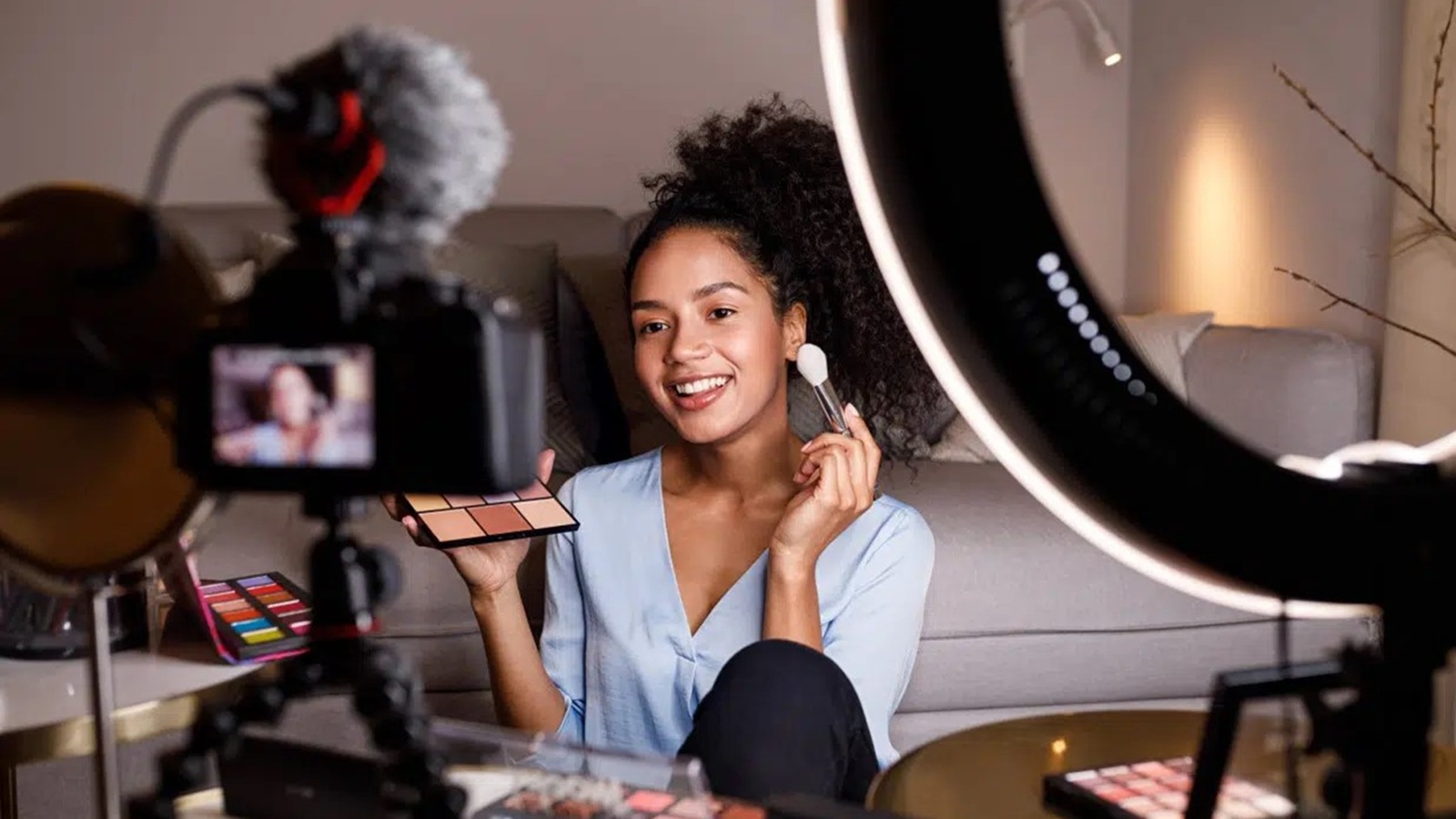 Influencerin schminkt sich vor der Kamera.