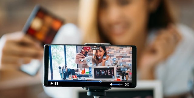 Ein Ausschnitt von einem Video auf dem Handy wie eine Frau live ist und sich mit der Handykamera filmt