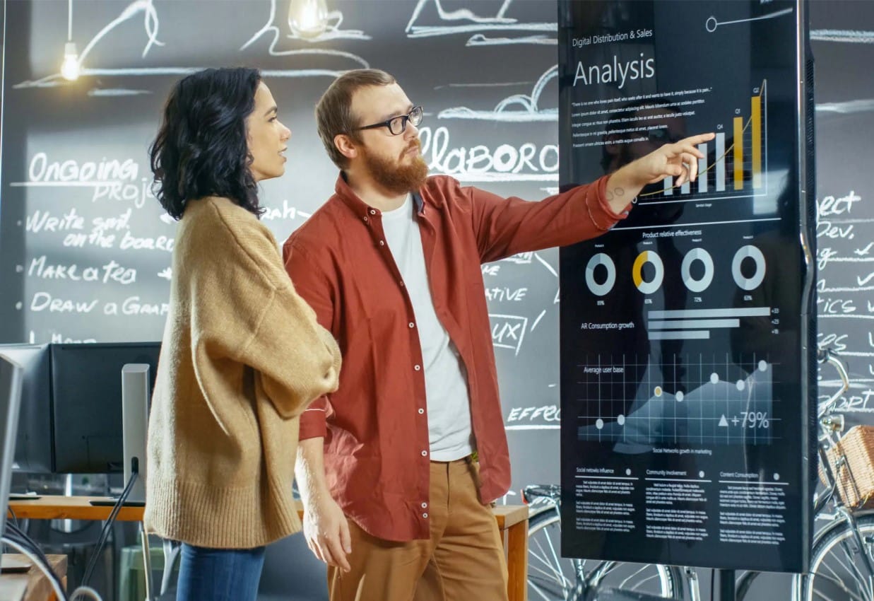 Digitaler Vertrieb ; zwei Leute besprechen eine Statistik