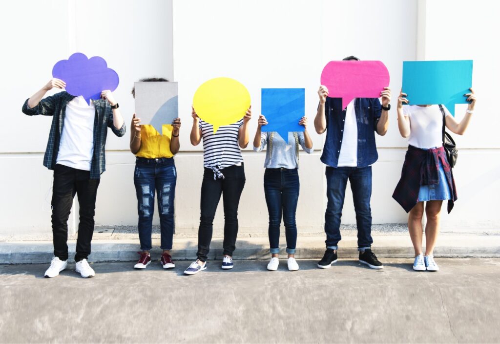 Social Media Kampagnen - sechs Personen stehen nebeneinander und halten bunte Sprechblasen in die Höhe