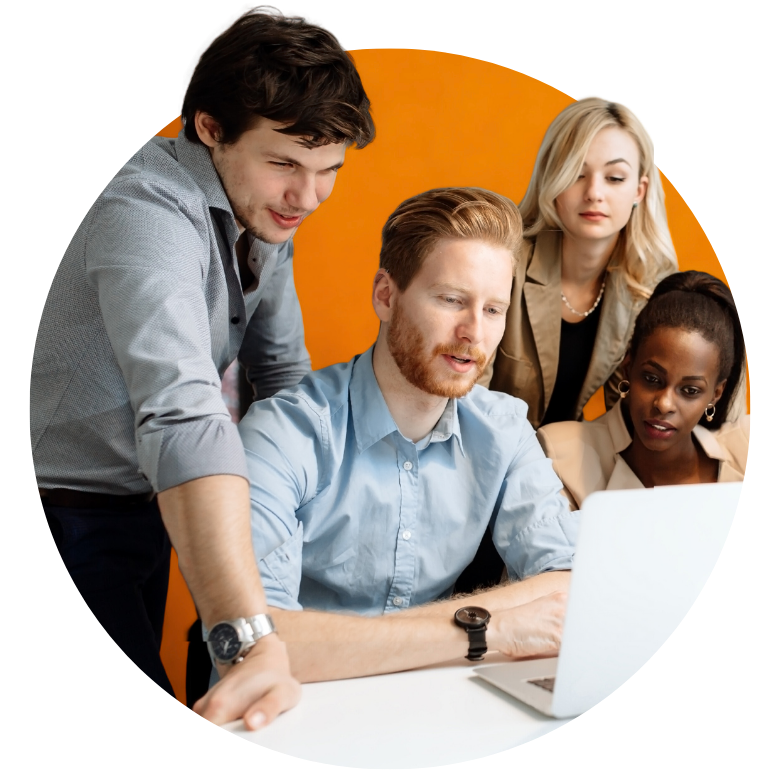 4 Personen sitzen in einer Arbeitssituation vor einem Laptop