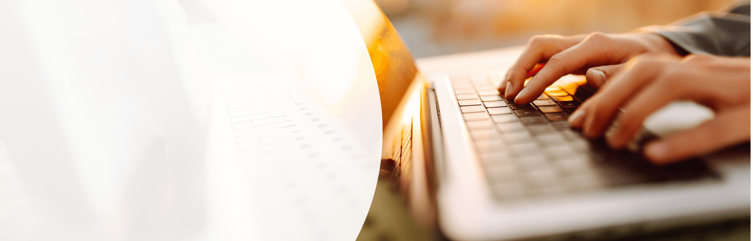 Hände tippen auf Laptop im warmen Licht des Sonnenaufgangs