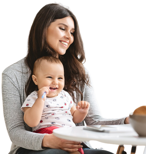 Mutter mit Kund auf dem Schoß sitzt an einem Schreibtisch