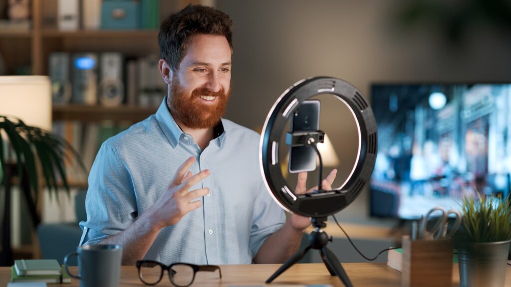 Mann macht Video Content Marketing mit Smartphone und Ringlicht.